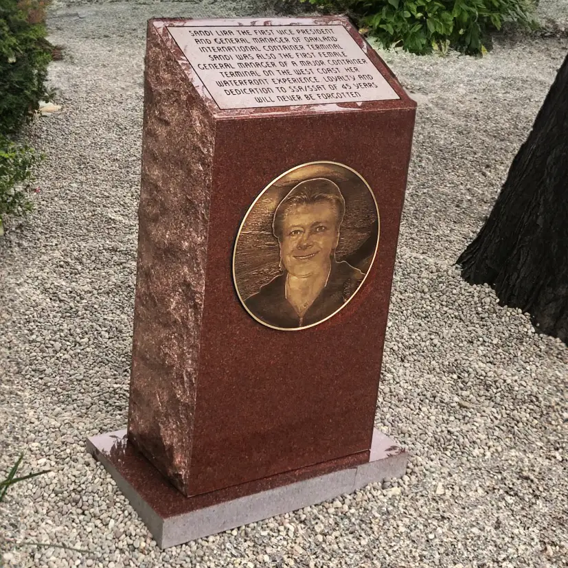 The Sandi Lira Monument Memorial in California made of brown granite with a bronze plaque and photo etching